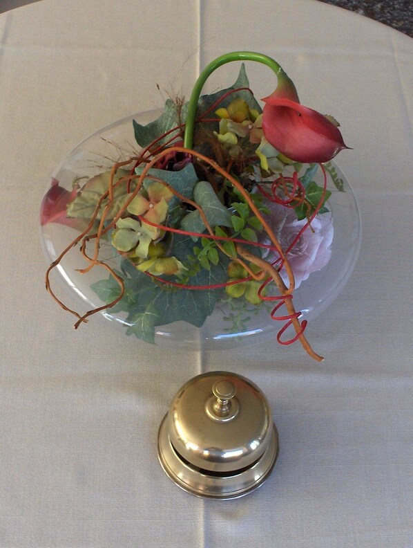 A clear glass vase with a flower arrangement on a table. - Hotel Mariani (Camaiore)