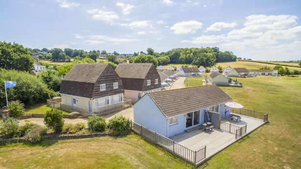 A residential area with houses, a grassy field, and a clear sky. - Seaview Holidays - Salterns Village (Seaview)