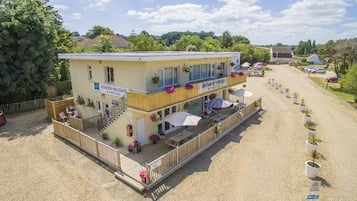 A two-story building with a sign for Seaview Holidays, outdoor seating, and a gravel driveway.