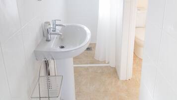 A bathroom with a sink, mirror, and shower curtain.