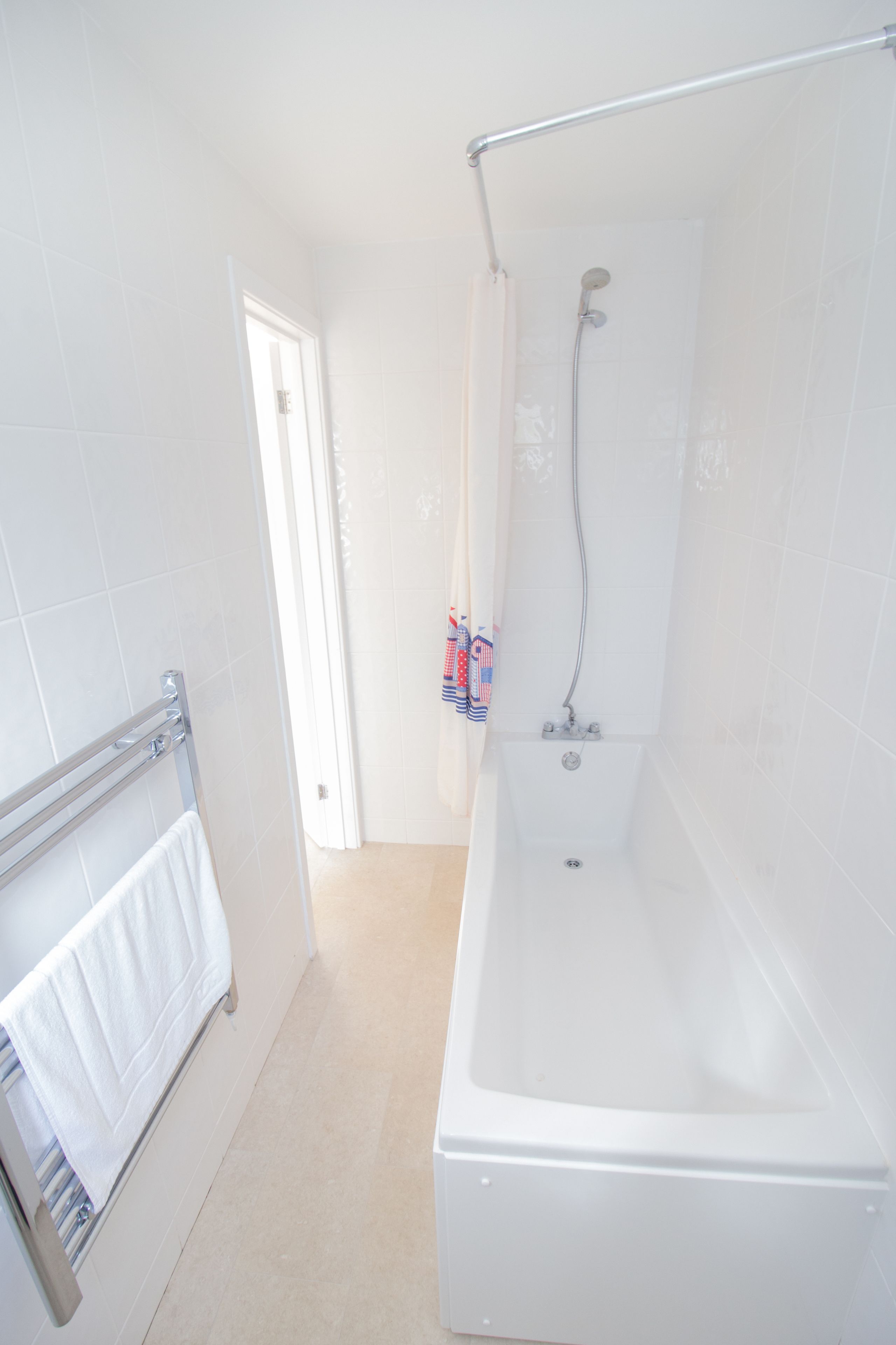 A bathroom with a bathtub, a shower, and a towel rack.