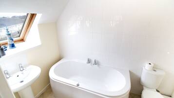 Ein Badezimmer mit Badewanne, Waschbecken und Toilette.