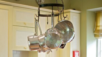 Una cocina con ollas y sartenes colgando.