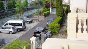 A view of a town with a church, parked cars, and a river. - Villa L'Orante (Lourdes)