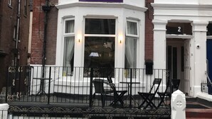 Um edifício de esquina com uma placa indicando 