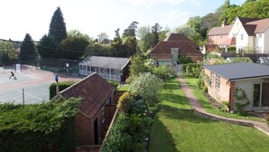 A residential area with a tennis court, a covered pavilion, and houses with gardens. - Hedingham Old Pottery (Halstead)