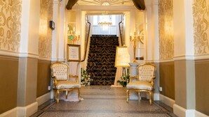 A grand entrance with a staircase, two ornate chairs, and a sign reading "Welcome to the City." - The City Rooms (Leicester)