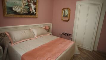 Quarto com cama, mesa de cabeceira, cômoda e uma pintura na parede.