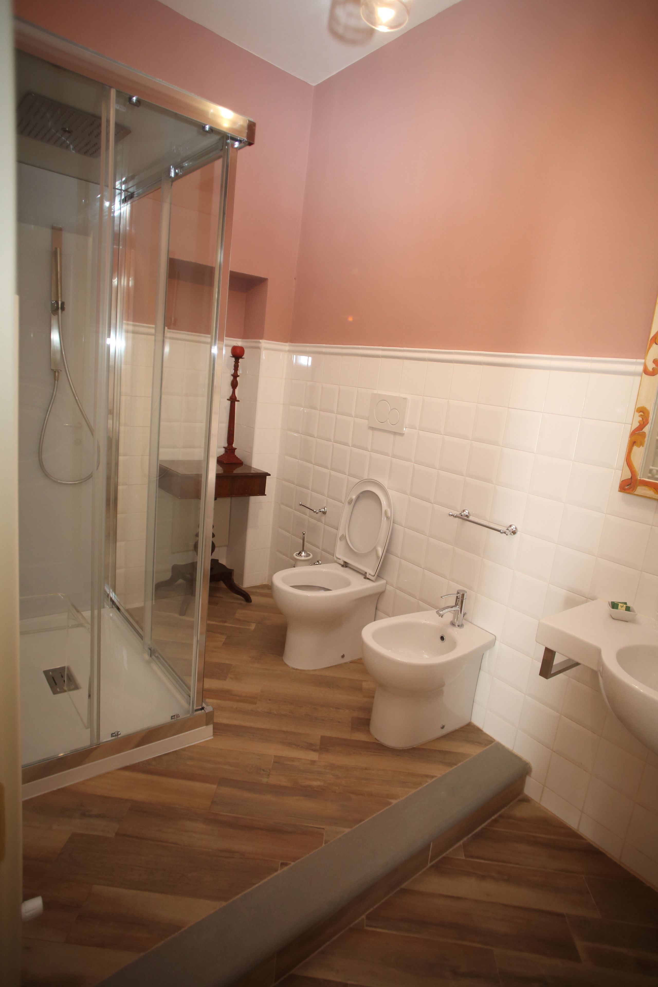 Une salle de bain avec une douche à parois de verre, des toilettes et un bidet.