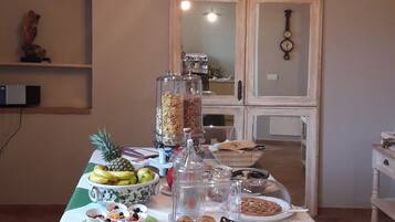 A dining table set with breakfast items, a clock, and a decorative wall piece.