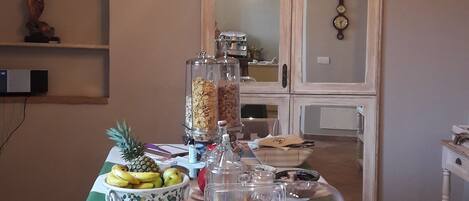 A dining table set with breakfast items, a clock, and a decorative wall piece.
