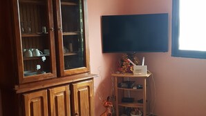 A room with a wooden cabinet, a flat-screen TV, and a window. - Residence Rom 4 Treicheville (Abidjan)