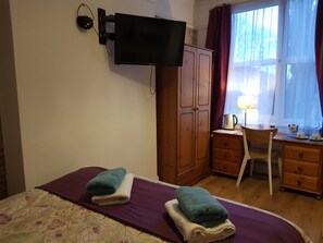 Enjoy a comfortable stay in this well-appointed room with a neatly made bed, TV, and desk area.