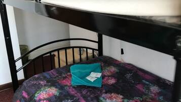Una litera con un colchón estampado con motivos florales y una almohada azul aguamarina.