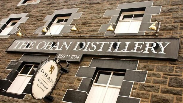 A sign for The Oban Distillery with a vintage design, established in 1794, and a visitor centre sign below it. - St. Annes Guest House (Oban)
