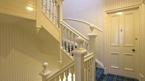 A staircase with white balusters and a blue plaid carpet. - St. Annes Guest House (Oban)