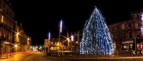 A Christmas tree illuminated with lights in a public square.