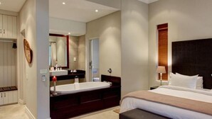 A modern hotel room with a large bed, a double vanity with a mirror, and a separate shower area. - Gaikou Lodge (Swellendam)