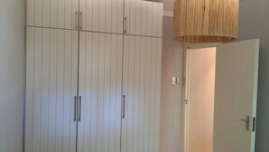 Una habitación con un armario grande, una puerta y una lámpara colgante.