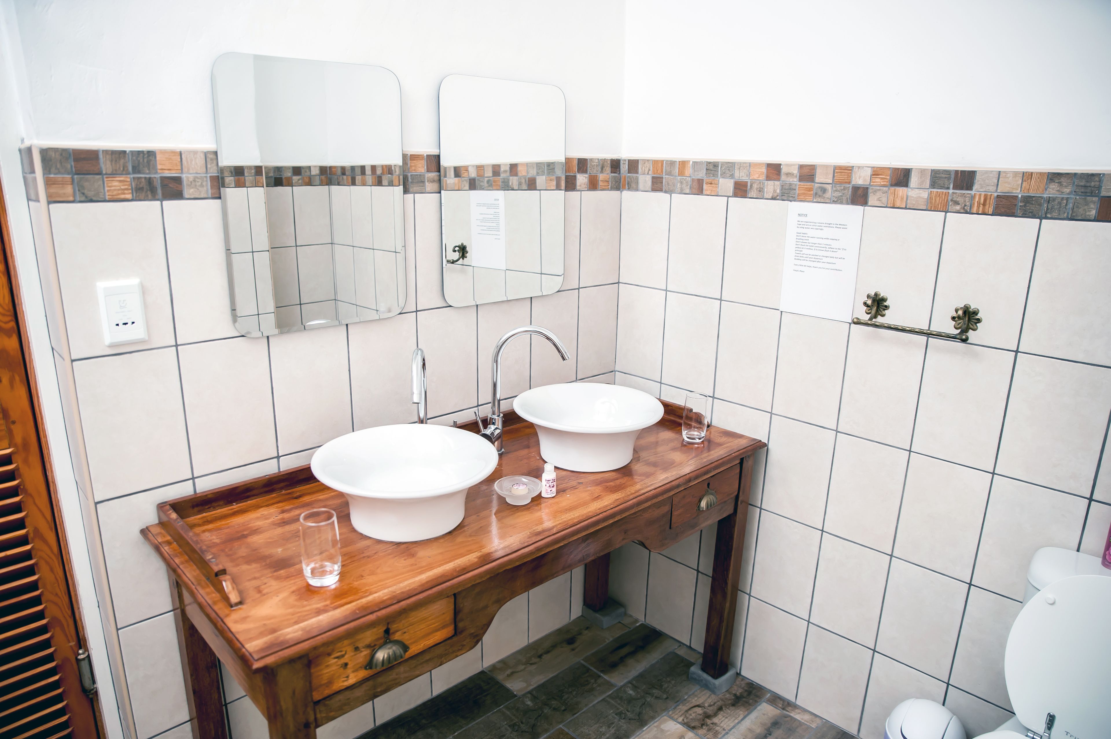 A bathroom with two sinks, a mirror, and a vanity with a tray.