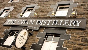 Un cartel de The Oban Distillery con un diseño vintage y un logotipo.