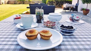 Taula amb taules quadrades i esmorzar que inclou muffins, bols de baies i una tassa de cafè.
