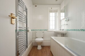 A bathroom with a toilet, sink, and bathtub. - Oystercatcher Apartments (Wadebridge)