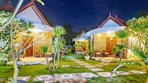 A well-lit courtyard with two guest rooms, each with a balcony and seating area. - Scoobydoo Bungalow (Lembongan Island)