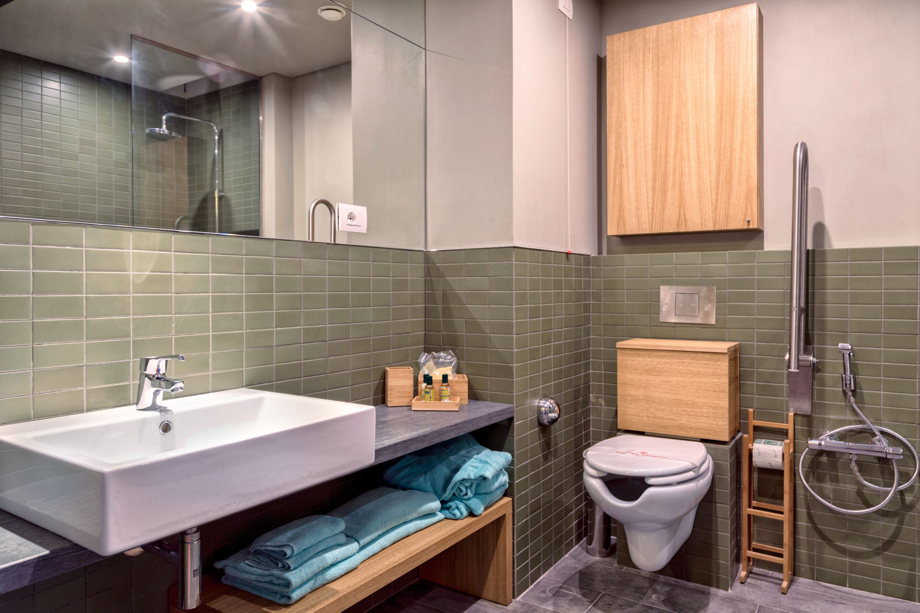 Een moderne badkamer met een wastafel, toilet en douche.