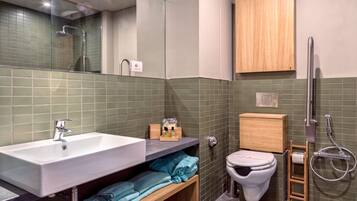 Een moderne badkamer met een wastafel, toilet en douche.