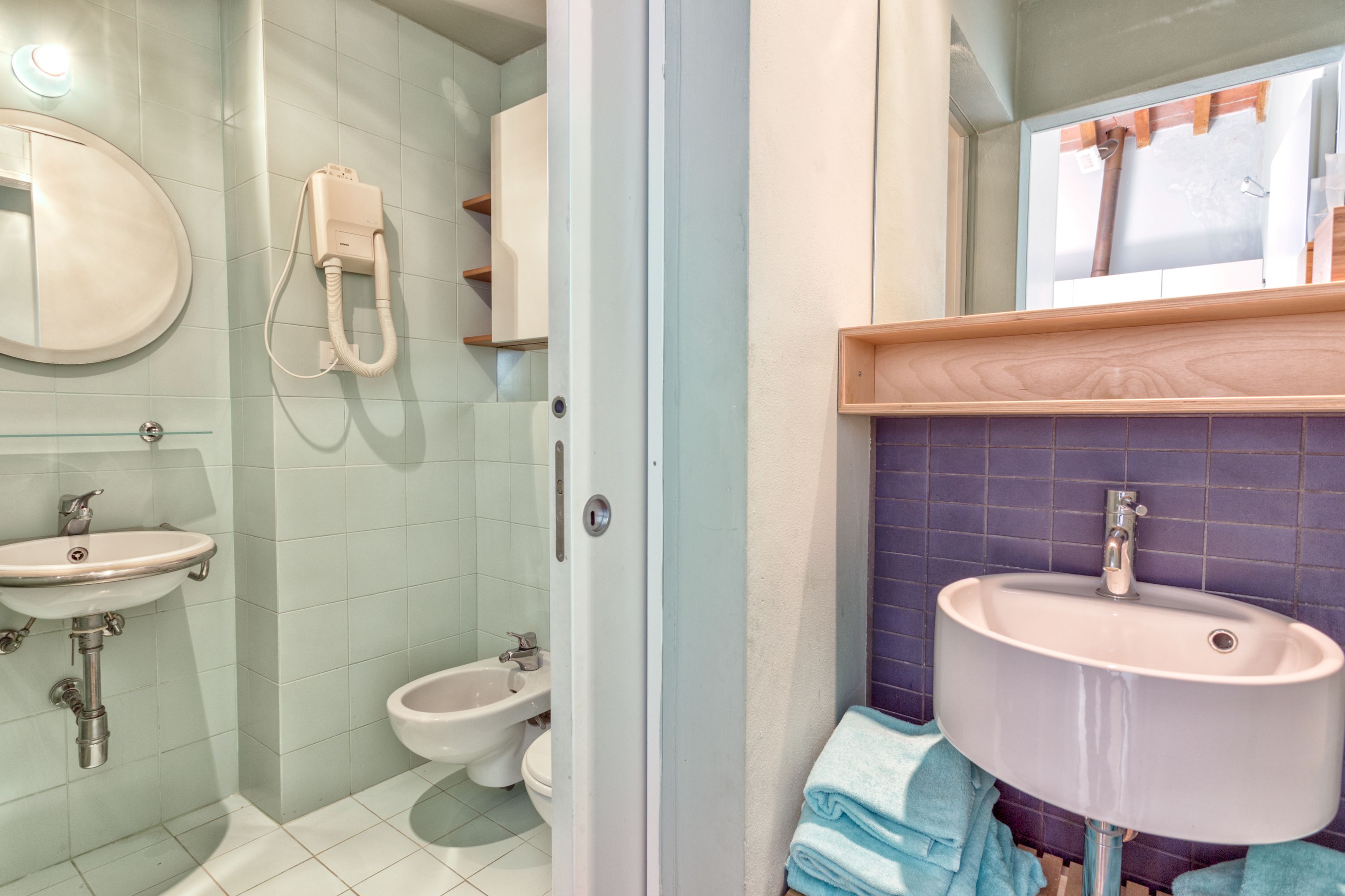 Un baño con lavamanos, bidé y espejo.