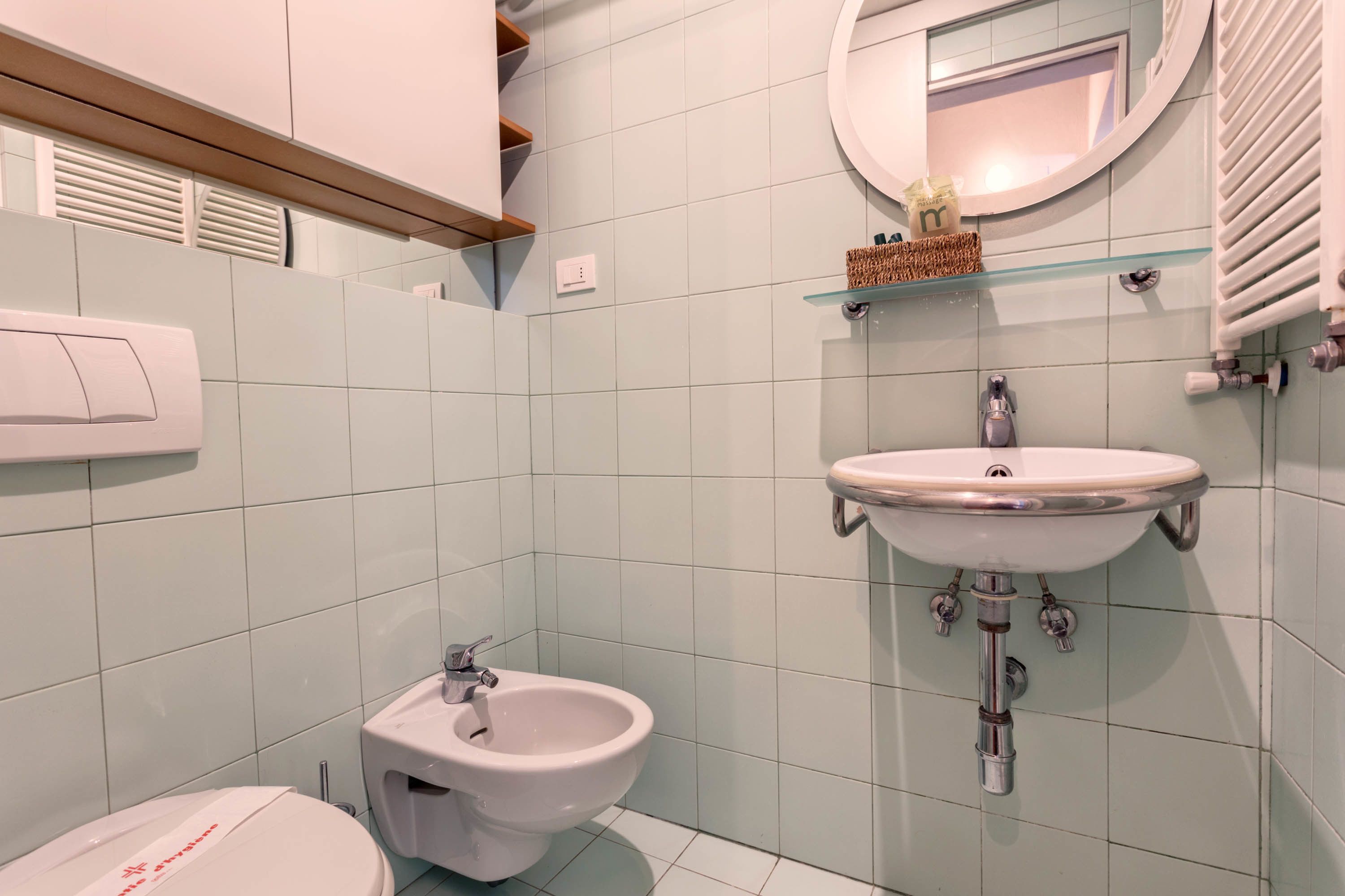 Un bagno con bidet, lavandino e specchio.