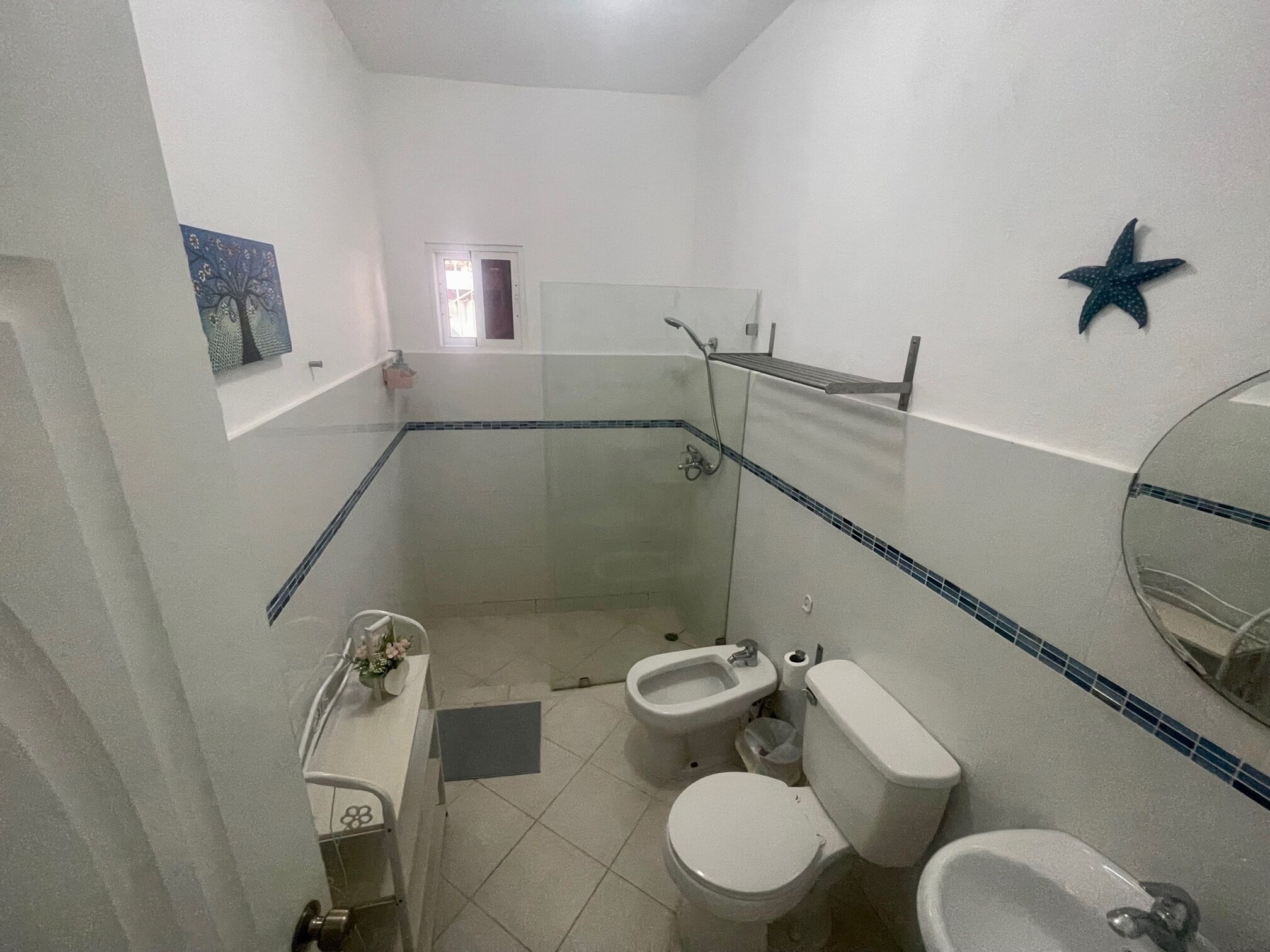 Un baño con ducha, inodoro, bidé y lavamanos.
