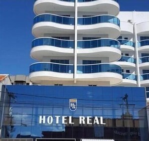 Hotel REAL features a distinctive architectural design with multiple balconies and glass railings.