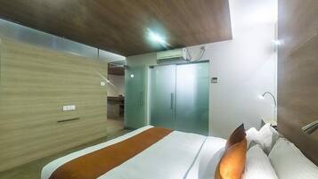 A hotel room with a bed, a wardrobe, and a door.