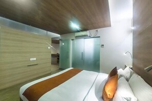 A hotel room with a bed, a wardrobe, and a door. - Hotel Rasika (Kolhapur)