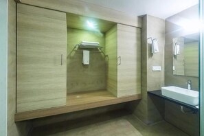 Un baño moderno con tocador de madera, lavabo y espejo.