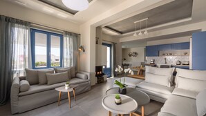 Una sala de estar moderna con un sofá, una mesa de centro y una cocina al fondo.