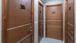 Un pasillo con tres puertas de madera, cada una con un número.