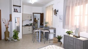 A modern apartment with a dining area, kitchen, and a living space. - Bed & Breakfast L'aquilino (Iglesias)