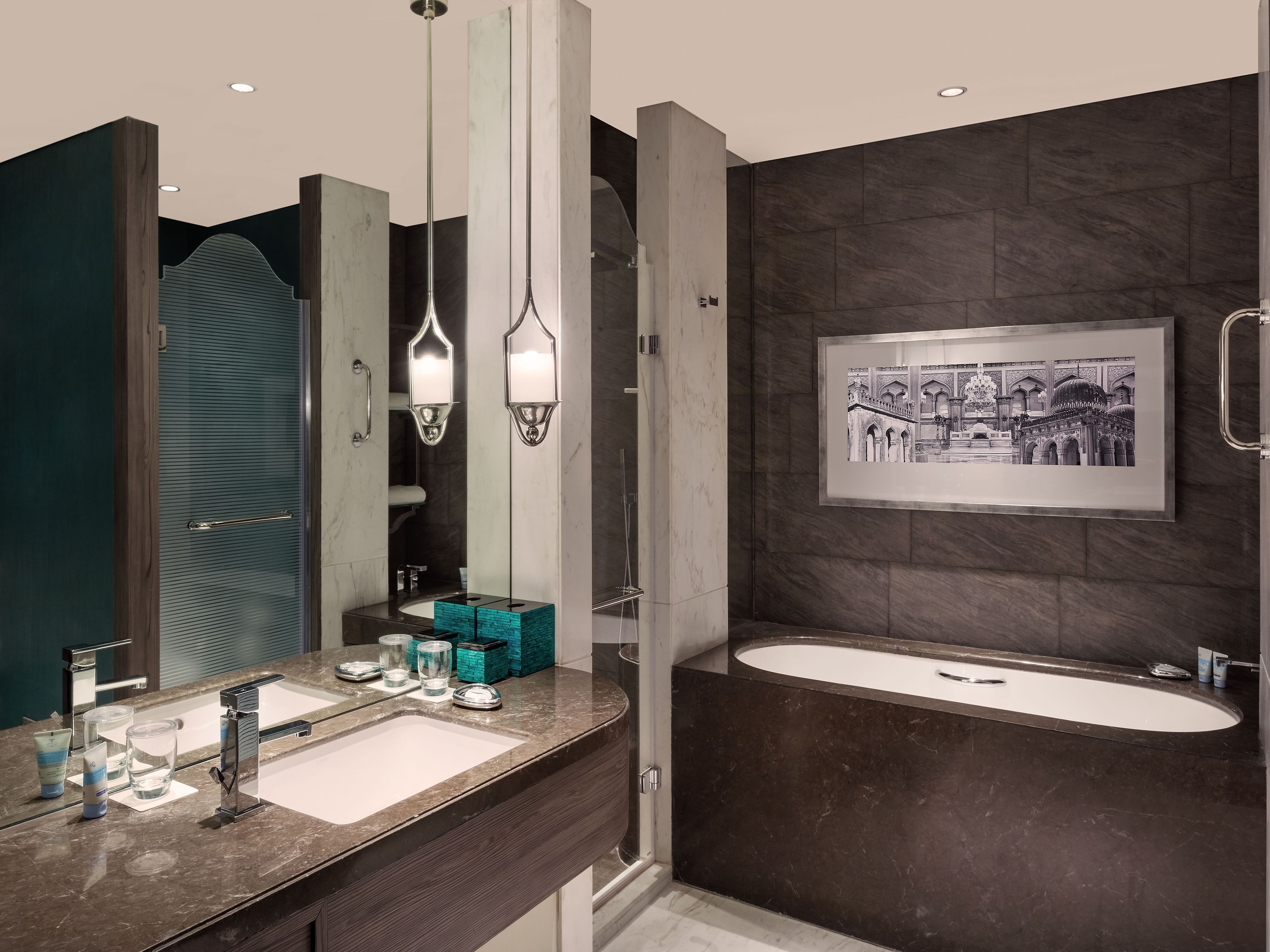 Un baño moderno con un espejo grande, dos lavamanos y una bañera.