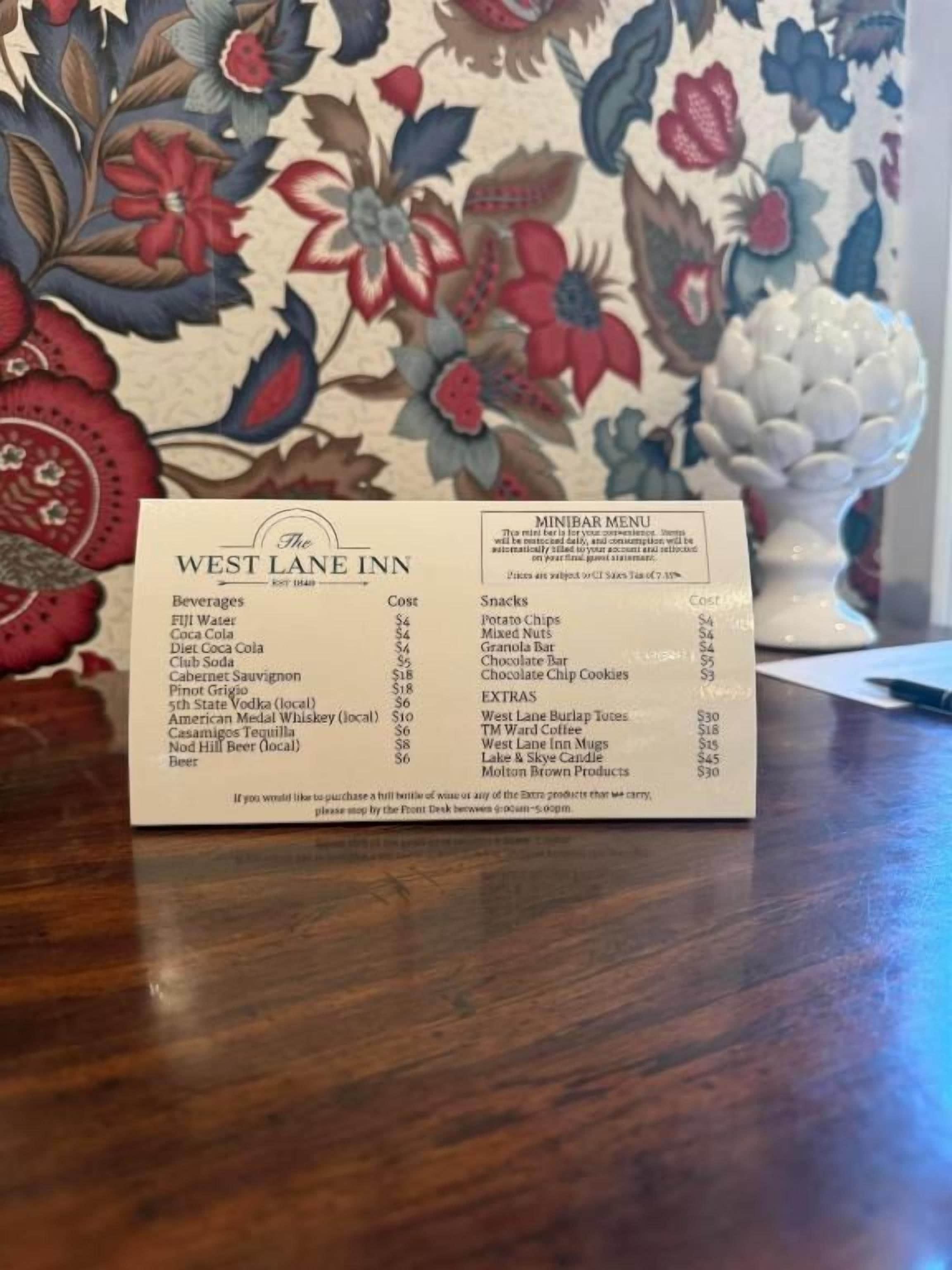 A menu from The West Lane Inn, listing beverages, snacks, and extras with their prices.