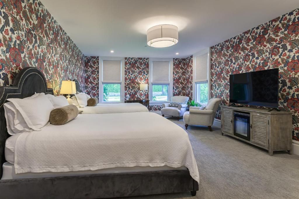 A bedroom with a large bed, two bedside tables, a television, and a cabinet.