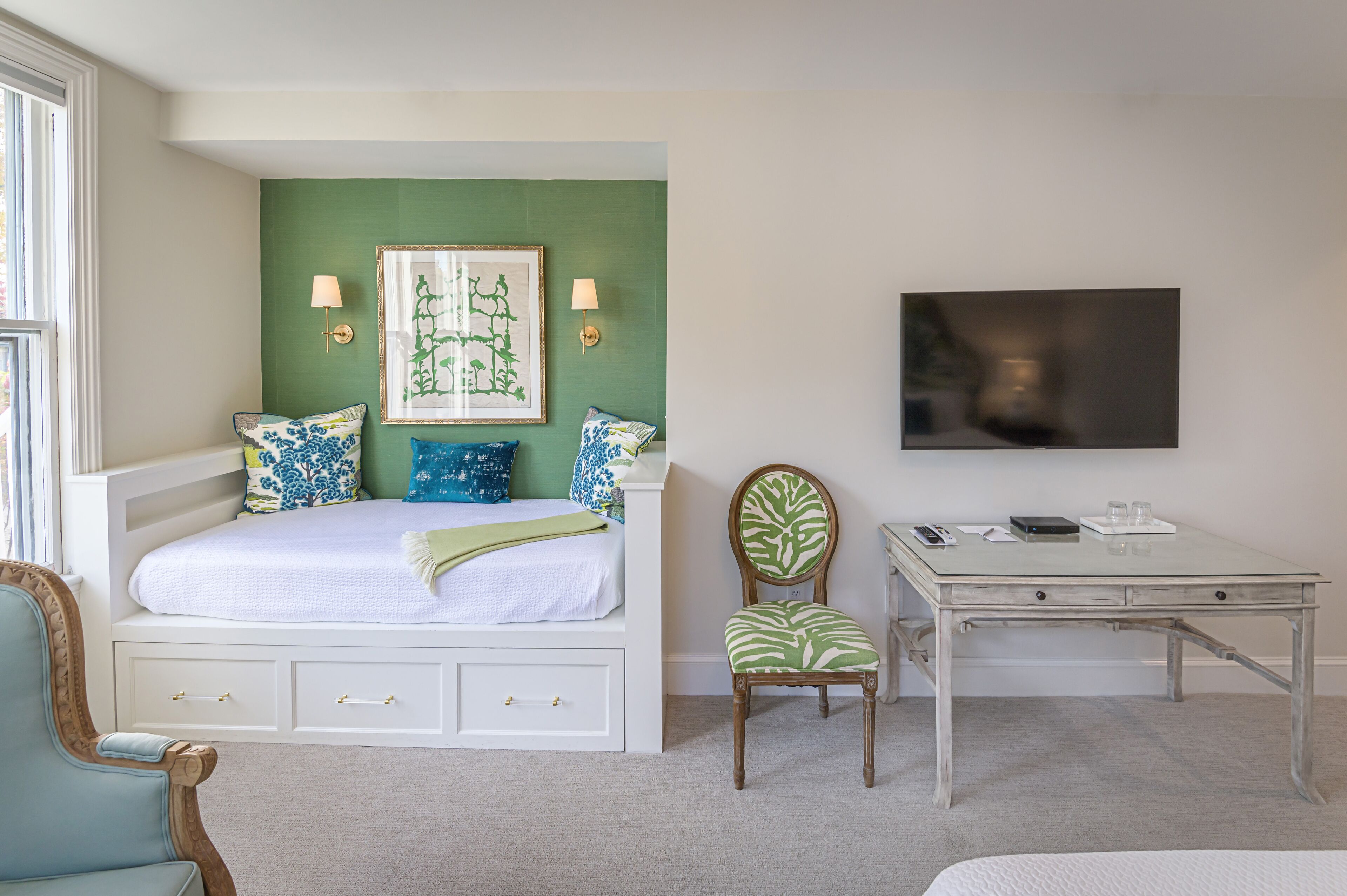 A bedroom with a bed, bedside tables, a desk, and a chair.