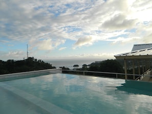 Una piscina amb vista a l'oceà i un pont a la distància.