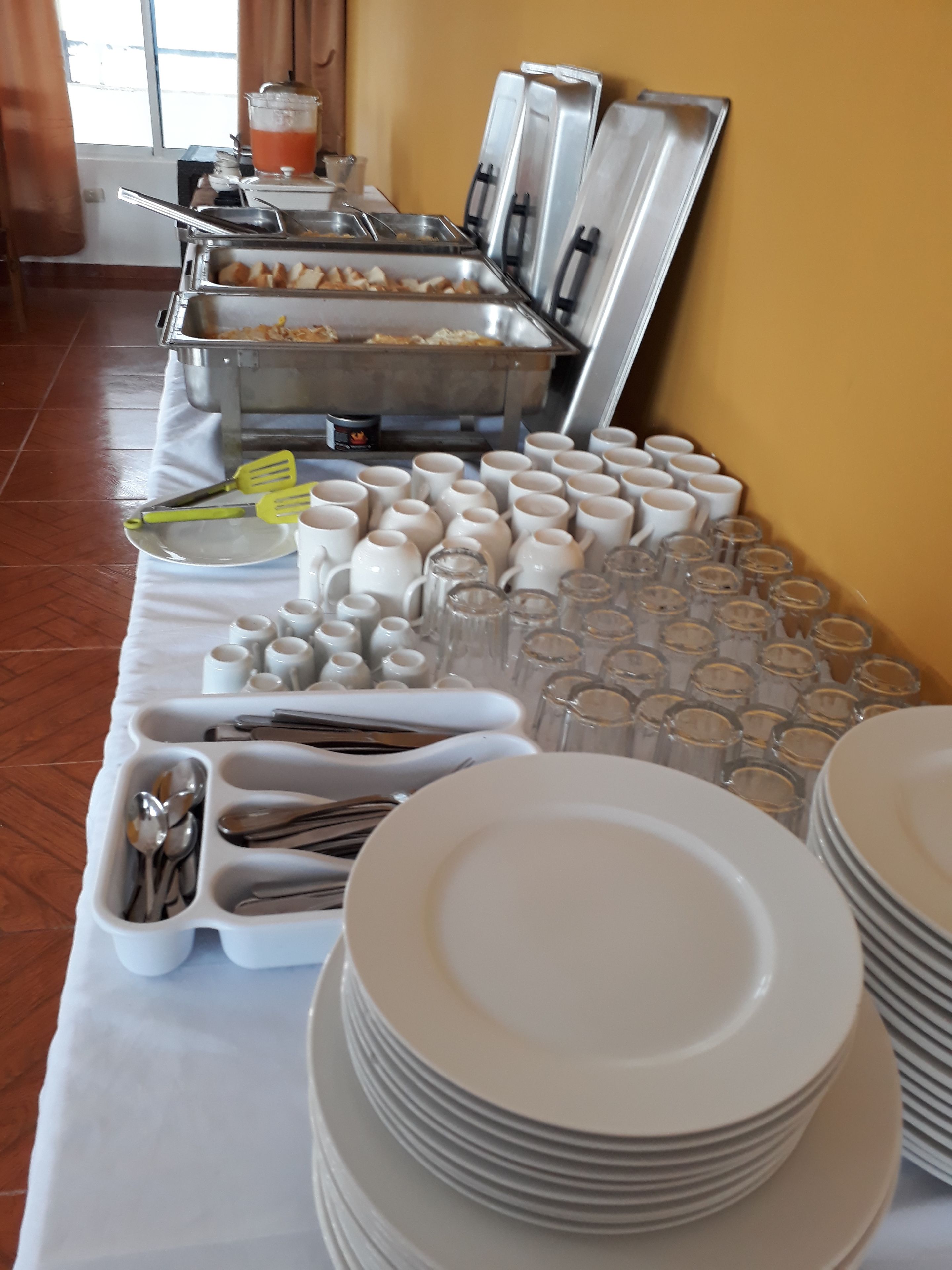 Disposição de buffet com diversos alimentos e utensílios.