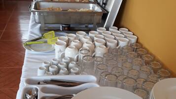 Disposição de buffet com diversos alimentos e utensílios.