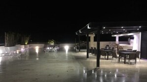 An outdoor patio area with a covered seating area and a bar. - Figaro Hotel Boutique (Samaná)