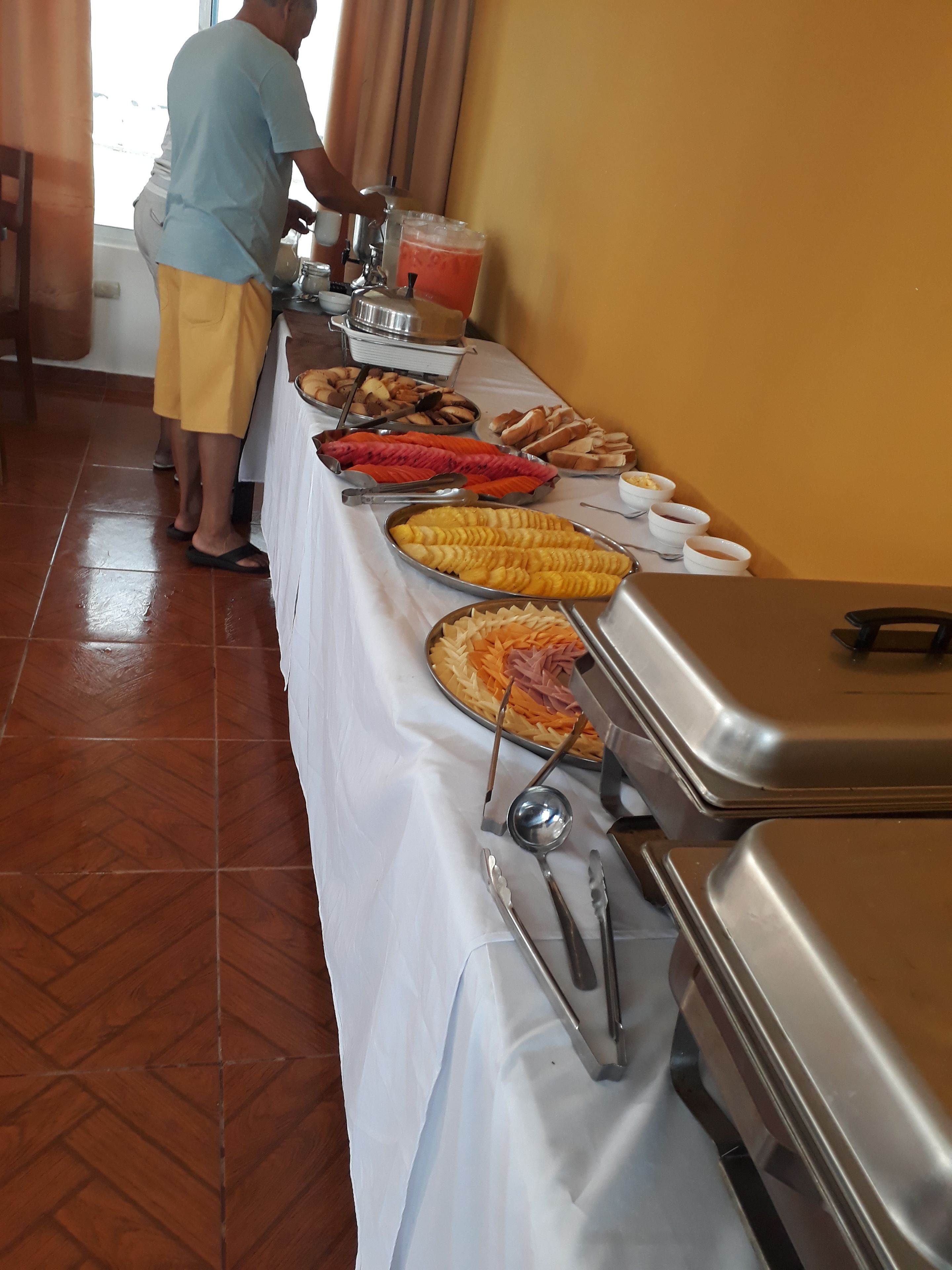 A buffet table with various food items and utensils.