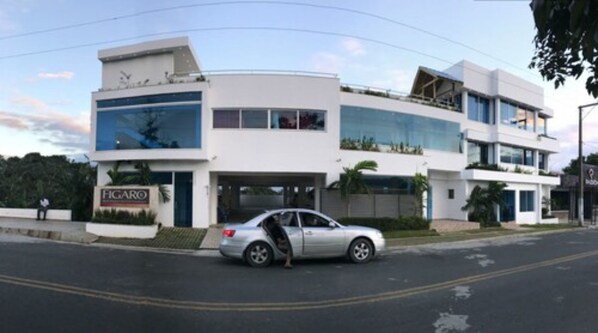 A modern two-story building with a car parked in front. - Figaro Hotel Boutique (Samaná)